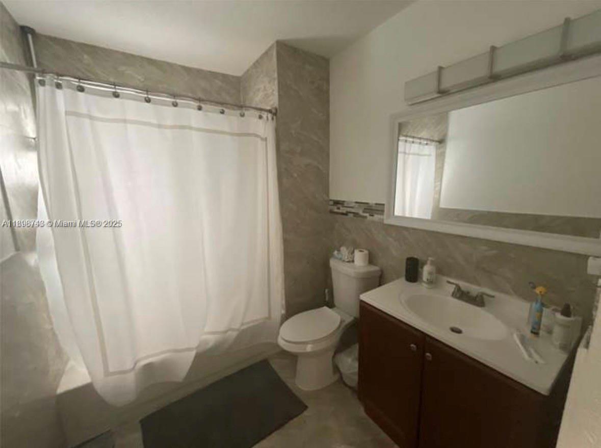 12100 Southwest 271st Street, Unit 12100 Homestead, FL 33032 - Photo 10 of 24 a bathroom with a sink a toilet a mirror a vanity and shower