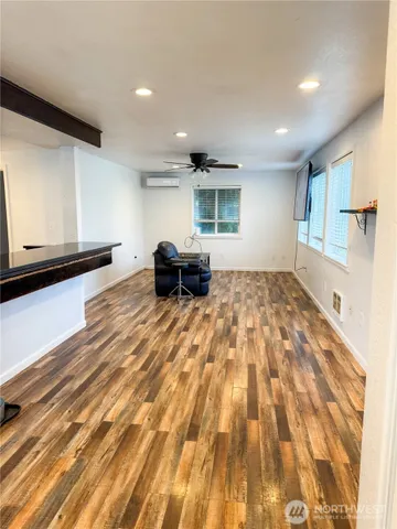 a view of empty room with wooden floor and window