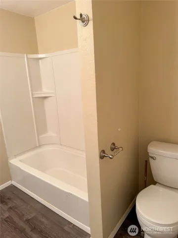 a white toilet sitting next to a bath tub