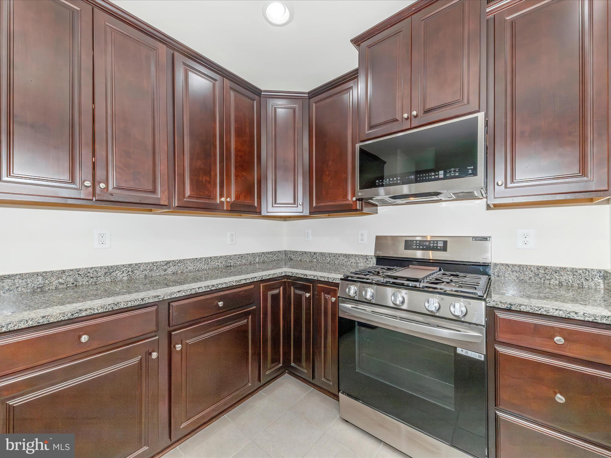 6501 Walcott Lane, Unit 202 Frederick, MD 21703 - Photo 13 of 53 a kitchen with granite countertop cabinets stainless steel appliances and a sink