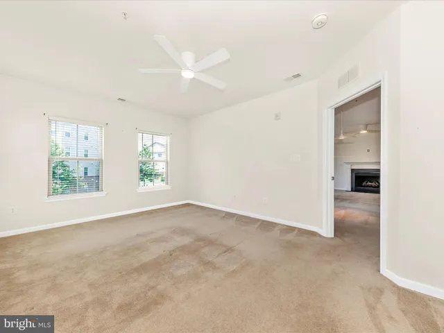 an empty room with closet and a ceiling fan