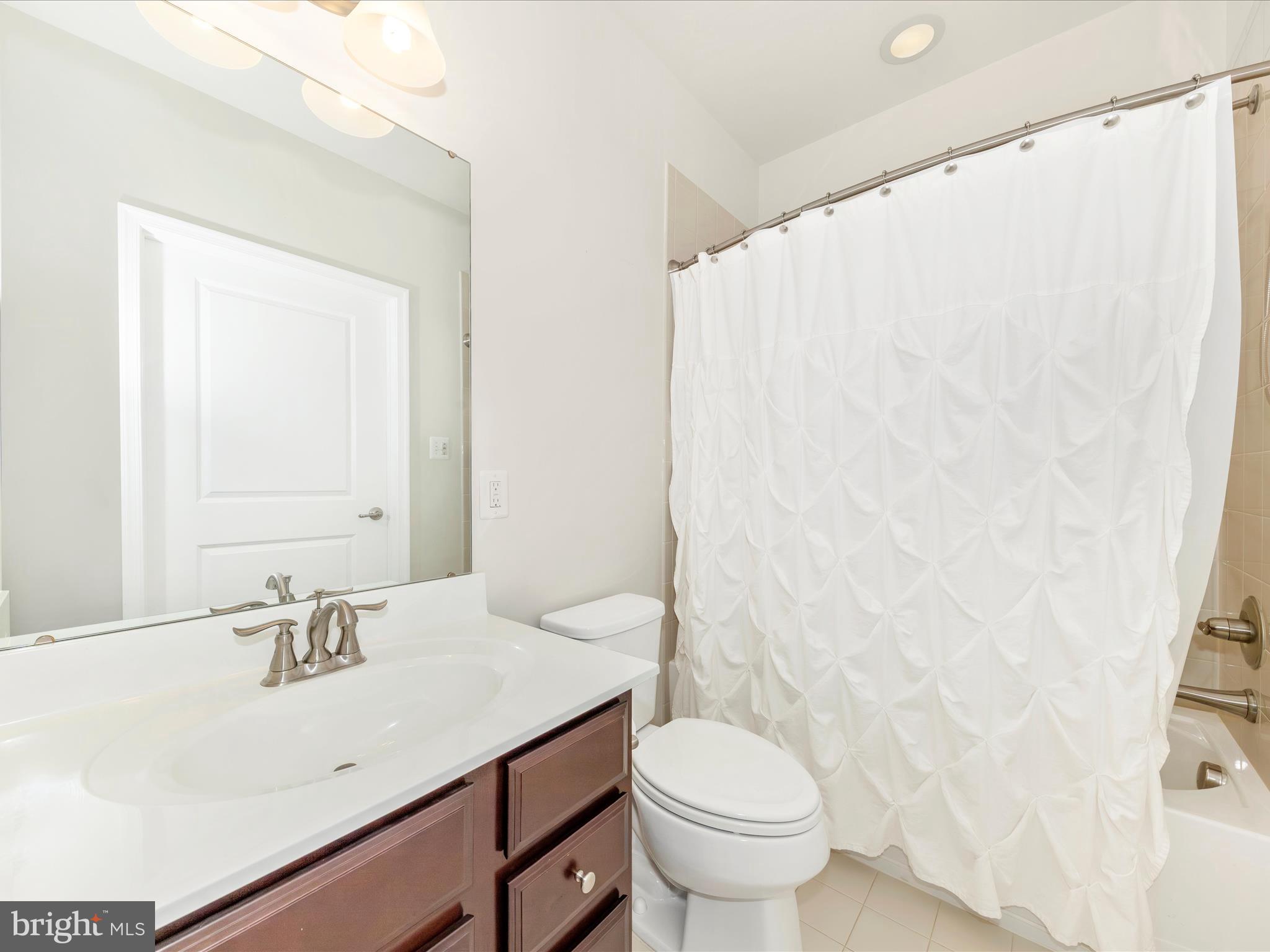 6501 Walcott Lane, Unit 202 Frederick, MD 21703 - Photo 30 of 53 a bathroom with a sink a toilet and a mirror