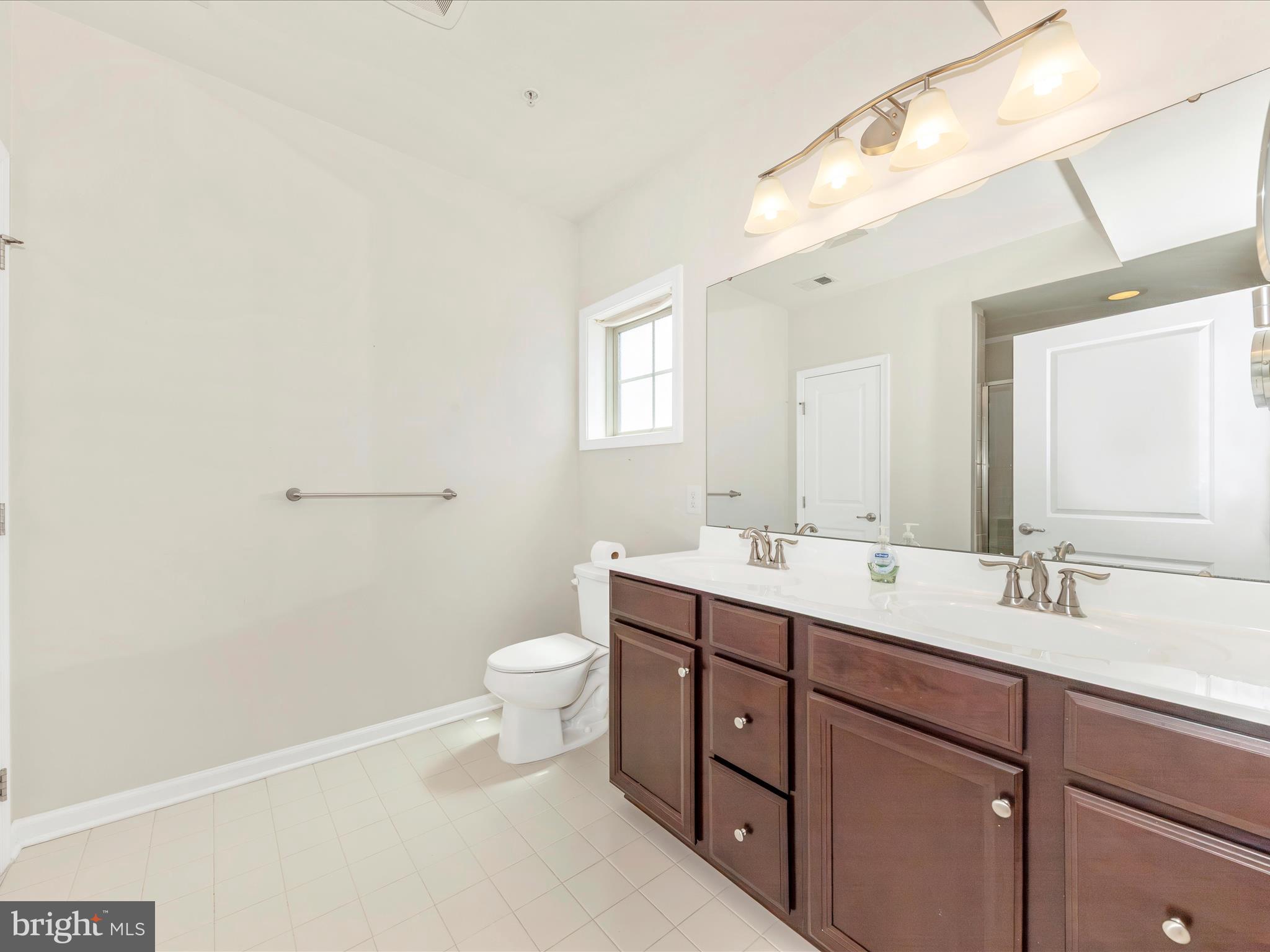 6501 Walcott Lane, Unit 202 Frederick, MD 21703 - Photo 8 of 53 a bathroom with a double vanity sink toilet and mirror