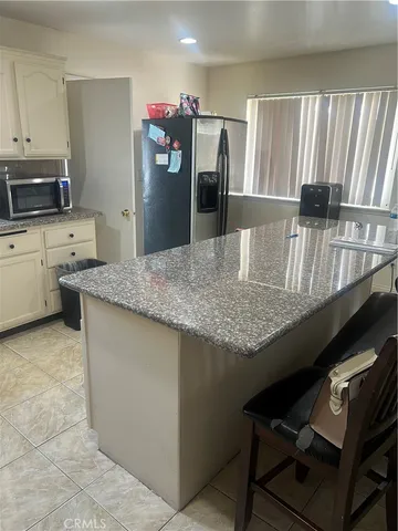 a kitchen with granite countertop a refrigerator a stove and a sink