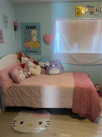 a bedroom with a bed and two windows