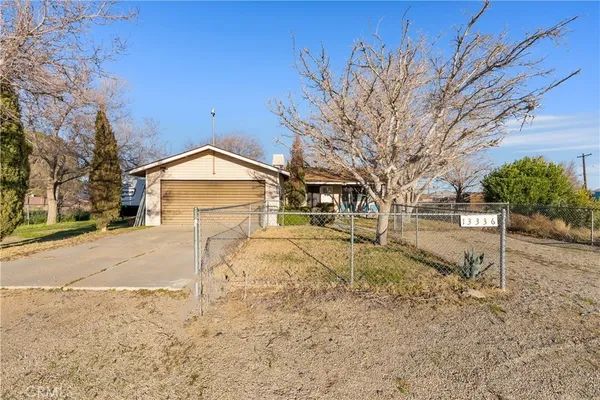 a view of large house with a yard covered in the road
