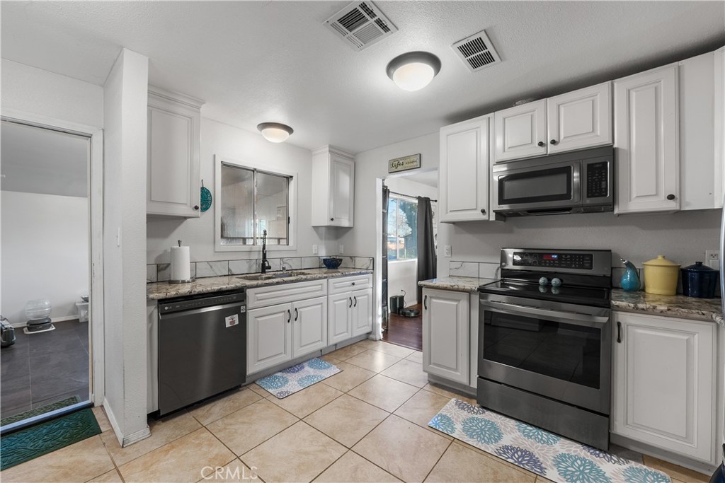 13336 Clement Edwards, CA 93523 - Photo 16 of 56 a kitchen with stainless steel appliances granite countertop a stove sink microwave and refrigerator