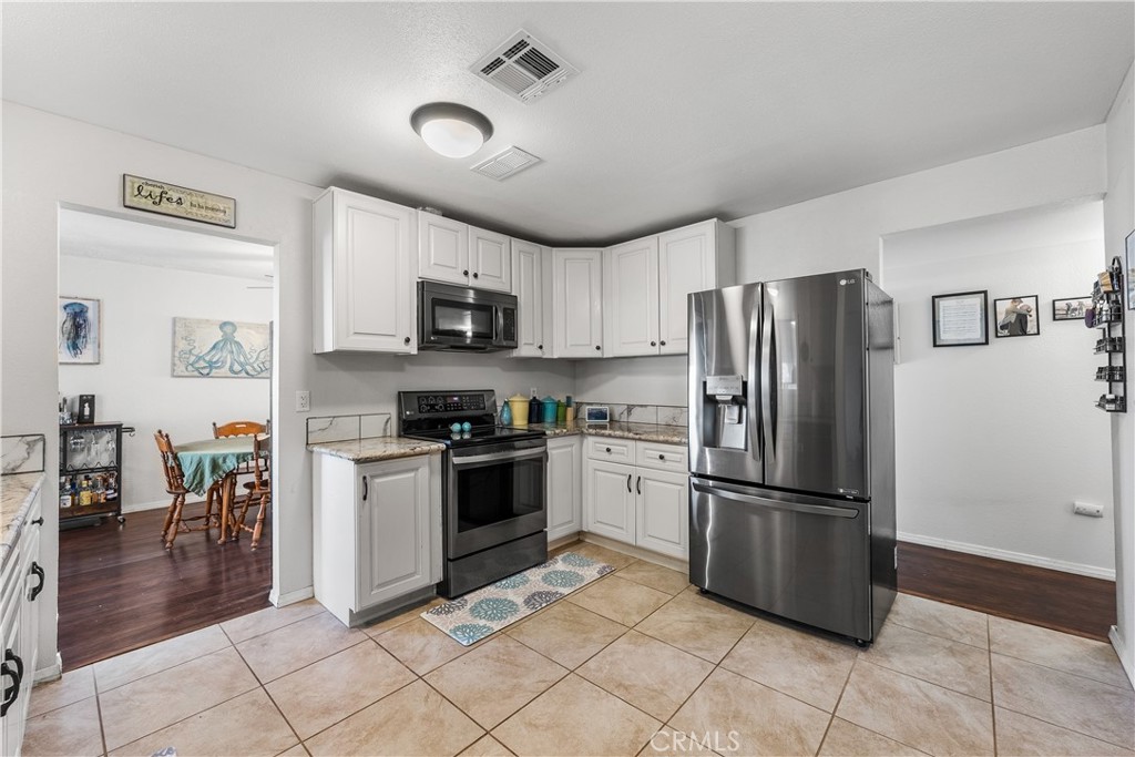 13336 Clement Edwards, CA 93523 - Photo 18 of 56 a kitchen with granite countertop a refrigerator and a stove top oven