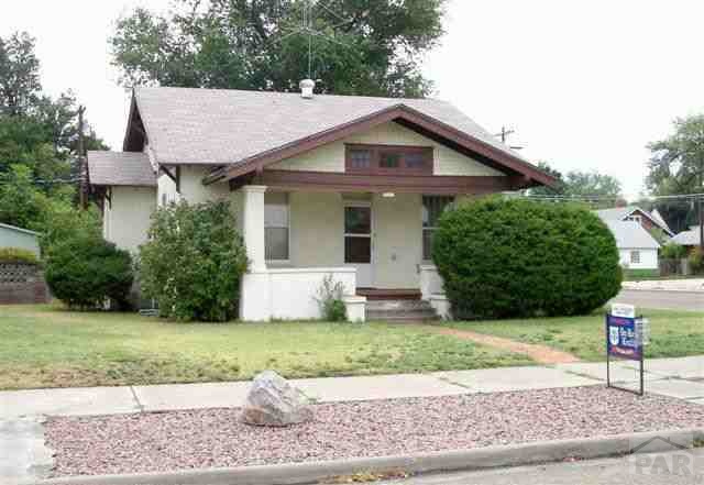 521 Raton Avenue La Junta, CO 81050 - Photo 1 of 1 a front view of a house with a yard and garage