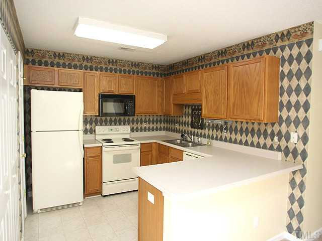 5518 Golden Moss Trail Raleigh, NC 27613 - Photo 5 of 13 a kitchen with a sink a stove and a refrigerator