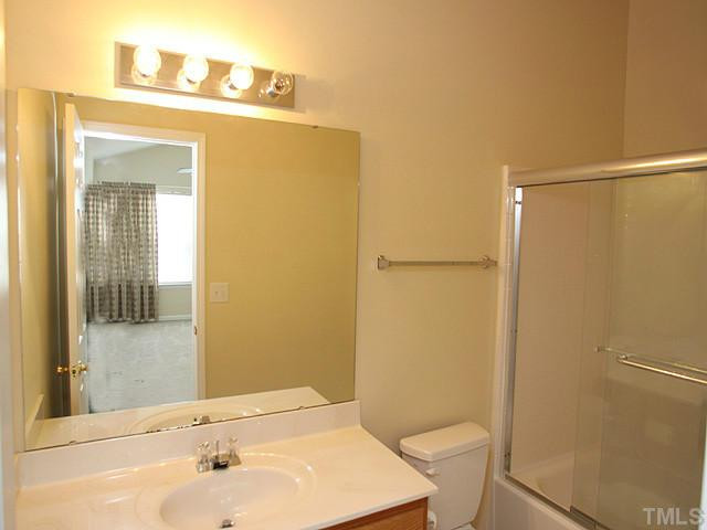 5518 Golden Moss Trail Raleigh, NC 27613 - Photo 8 of 13 a bathroom with a sink a toilet a shower and a mirror