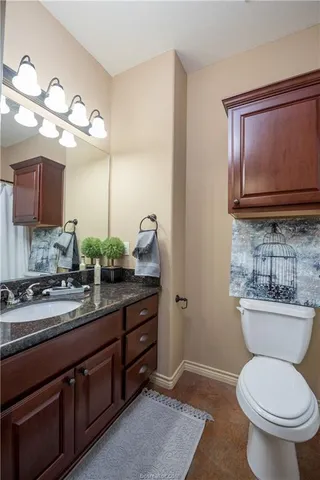 a bathroom with a toilet a sink and a mirror