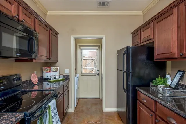 a kitchen with stainless steel appliances granite countertop a refrigerator stove and sink