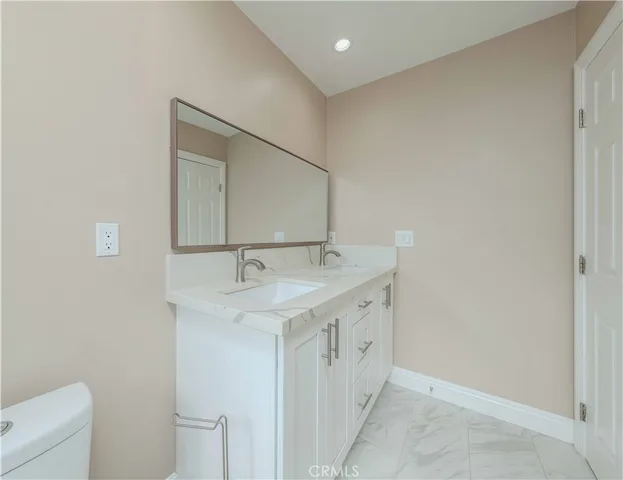 a bathroom with a sink a toilet and mirror