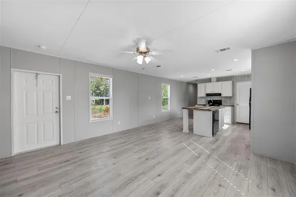 a view of kitchen with granite countertop cabinets and window