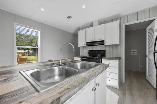 a kitchen with stainless steel appliances granite countertop a sink a refrigerator and a granite counter tops