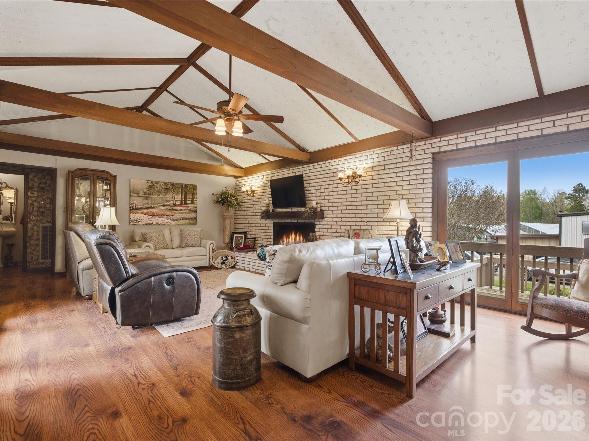 2620 Reeves Island Road Gold Hill, NC 28071 - Photo 18 of 48 a living room with furniture a flat screen tv and a floor to ceiling window