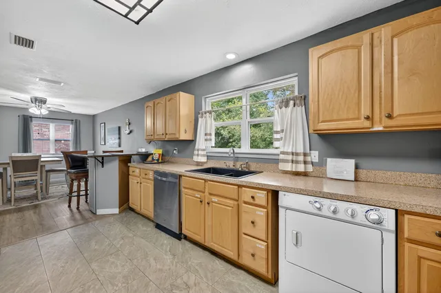 a kitchen with cabinets appliances a sink and a window