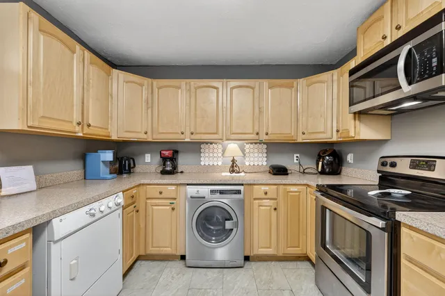 a kitchen with stainless steel appliances granite countertop a stove a refrigerator and a cabinets with wooden floor