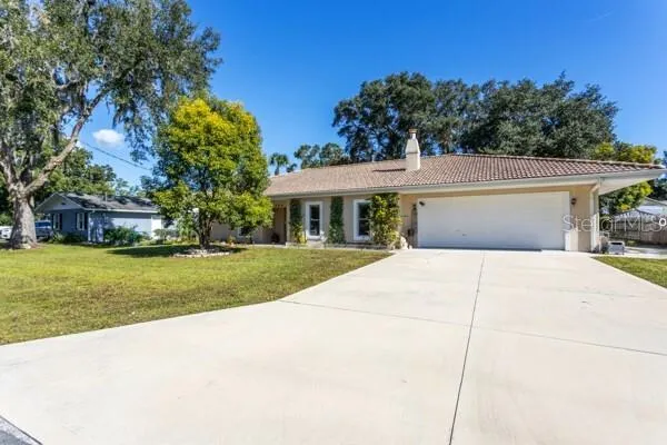 a view of house with outdoor space garden and tree
