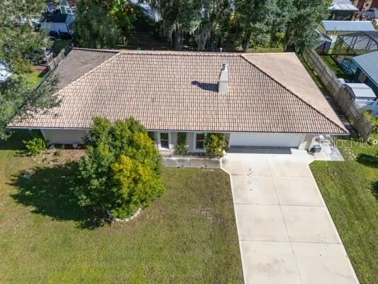 a aerial view of a house with plants and large trees