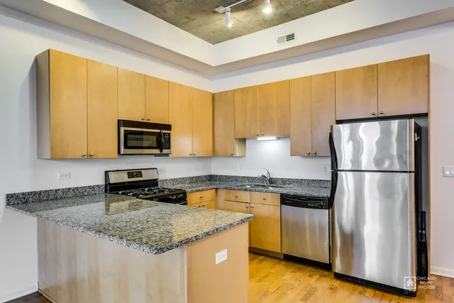 a kitchen with stainless steel appliances granite countertop a refrigerator a sink a stove a microwave and island