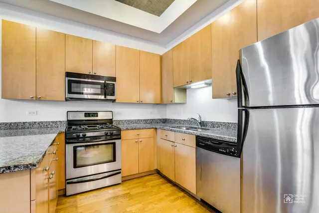 a kitchen with granite countertop a refrigerator stove and microwave