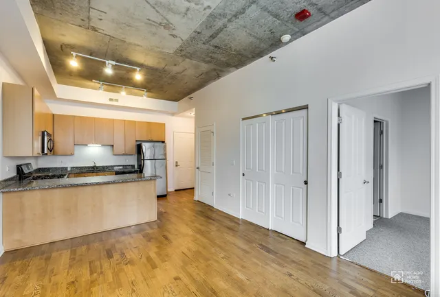 a large white kitchen with stainless steel appliances granite countertop a stove a sink and a refrigerator