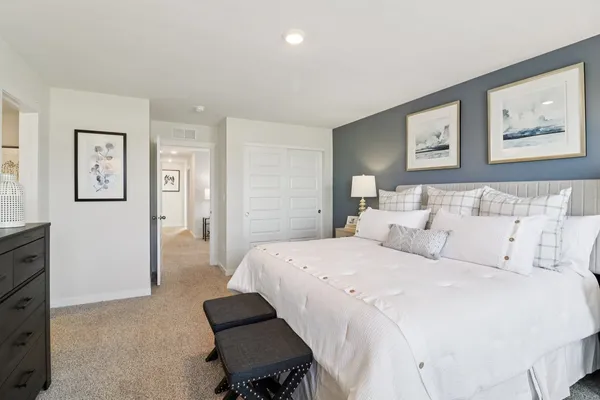 a bedroom with a bed and a painting on the wall