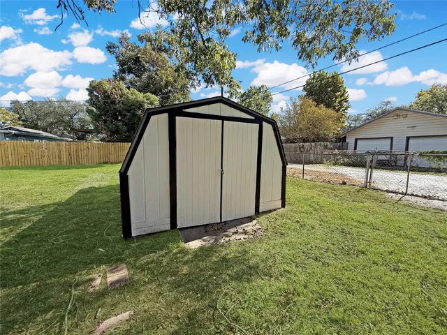 a view of a backyard with a garden and tree