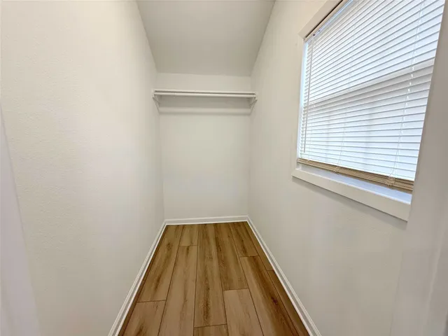 a small space with wooden floor and a window