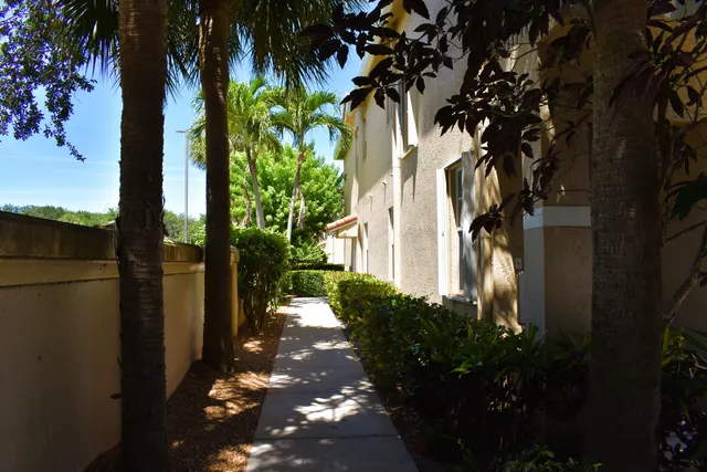 a backyard of a house with table and chairs potted plants