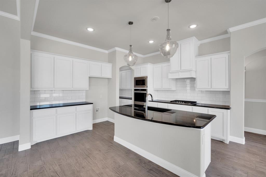 395 Haven Road Waxahachie, TX 75165 - Photo 10 of 40 a large kitchen with granite countertop a white stove top oven and white cabinets