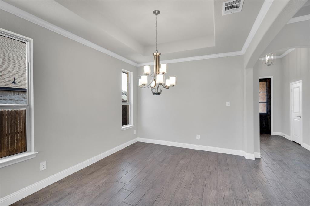 395 Haven Road Waxahachie, TX 75165 - Photo 9 of 40 a view of a chandelier in a room with wooden floor and ceiling fan