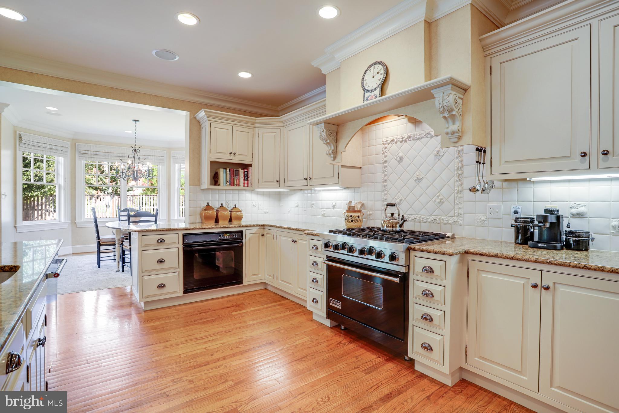 5629 Newington Road Bethesda, MD 20816 - Photo 12 of 65 a kitchen with stainless steel appliances white cabinets a stove a sink and a wooden floors