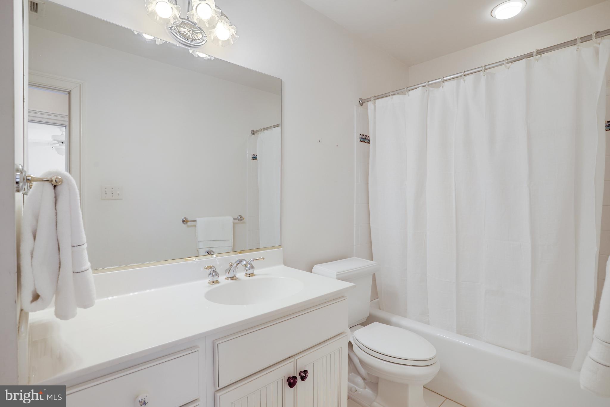 5629 Newington Road Bethesda, MD 20816 - Photo 46 of 65 a bathroom with a sink a toilet and shower curtain