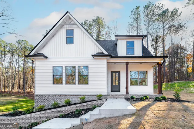 a front view of a house with a garden and yard