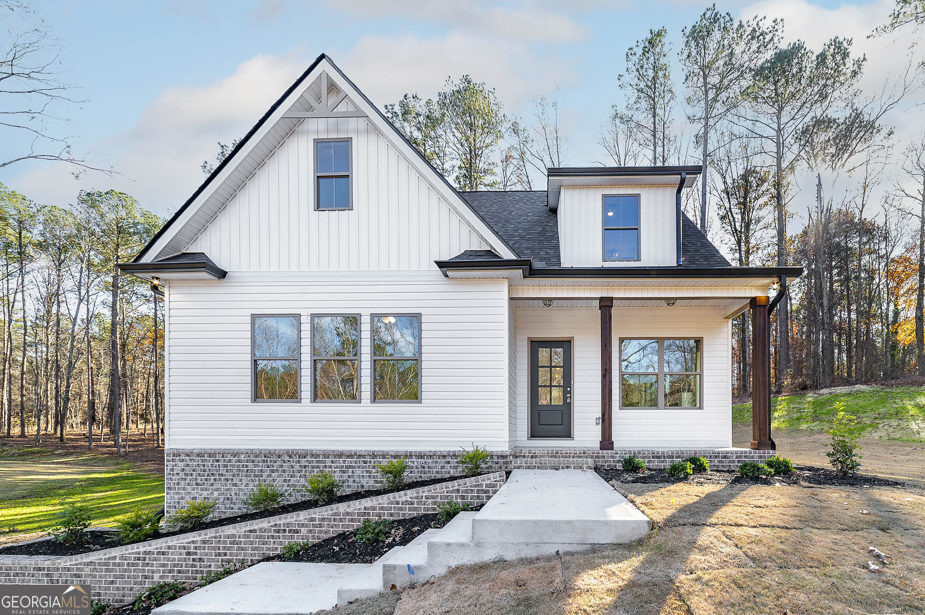 a front view of a house with a garden and yard