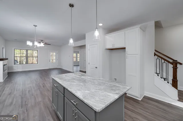 a kitchen with stainless steel appliances kitchen island granite countertop a stove a sink and a microwave