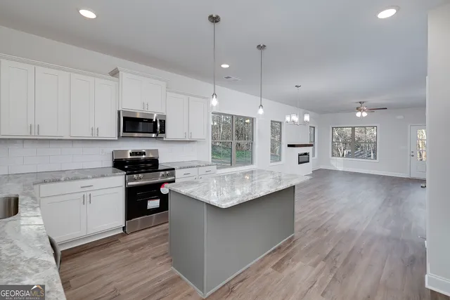 a large kitchen with kitchen island a sink stainless steel appliances and cabinets