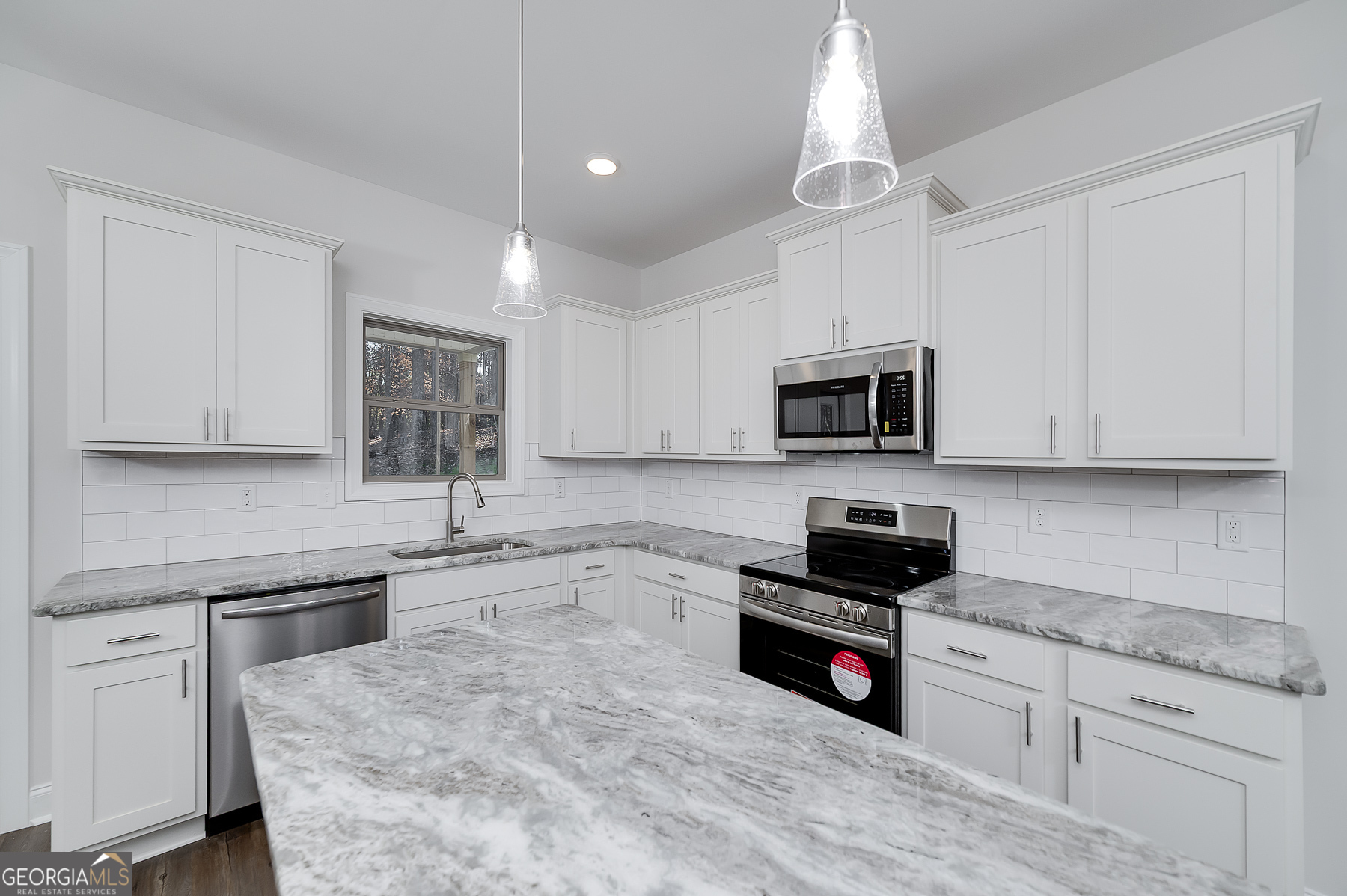 245 Pelican Circle Monticello, GA 31064 - Photo 16 of 37 a kitchen with granite countertop a stove a sink and a microwave