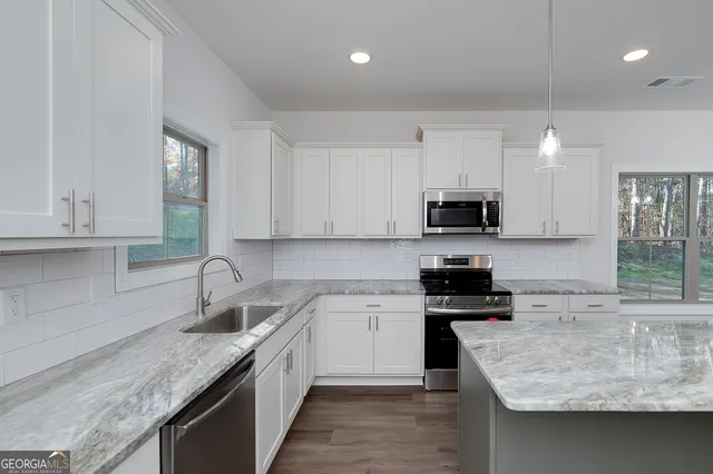 a view of a kitchen with wooden floor and a sink