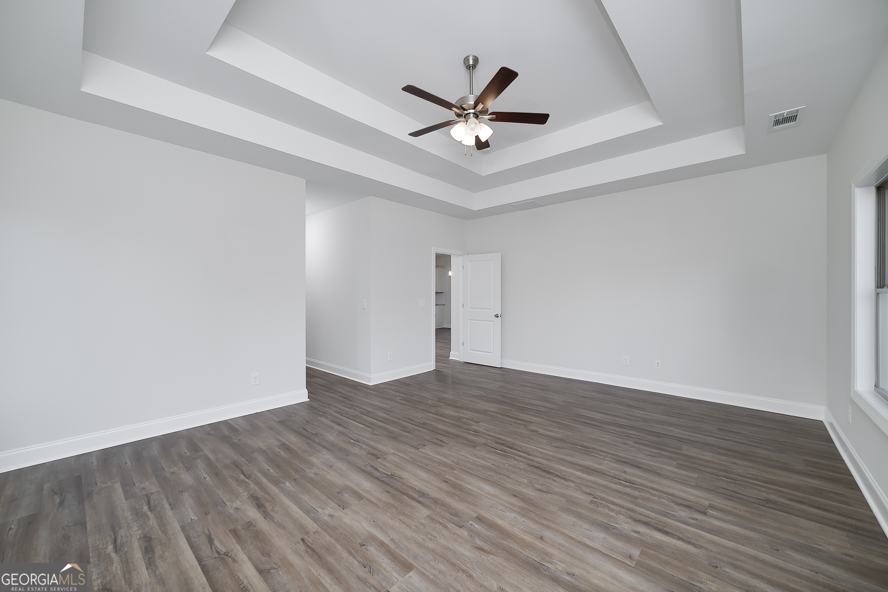 245 Pelican Circle Monticello, GA 31064 - Photo 21 of 37 a view of an empty room with wooden floor and a ceiling fan