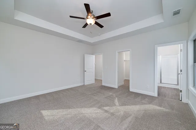 an empty room with windows and fan