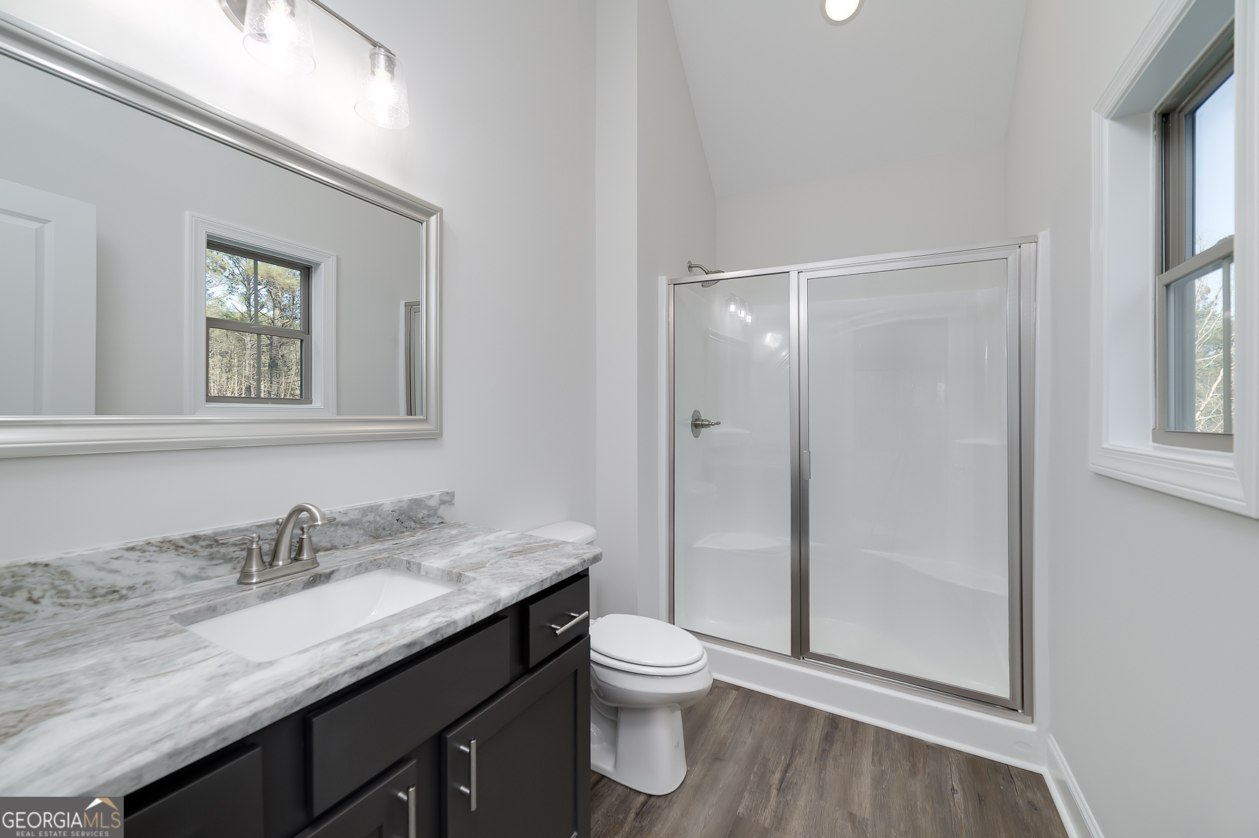 245 Pelican Circle Monticello, GA 31064 - Photo 28 of 37 a bathroom with a granite countertop sink toilet a mirror and shower