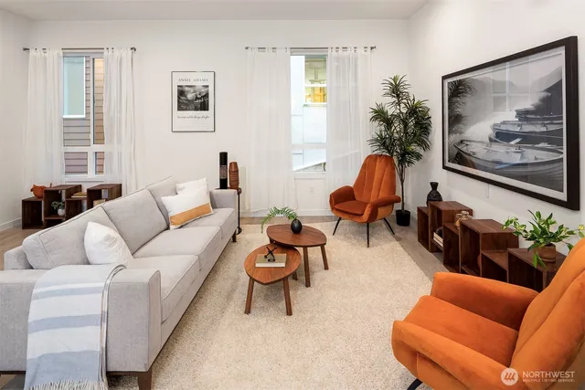 a living room with furniture kitchen view and a large window