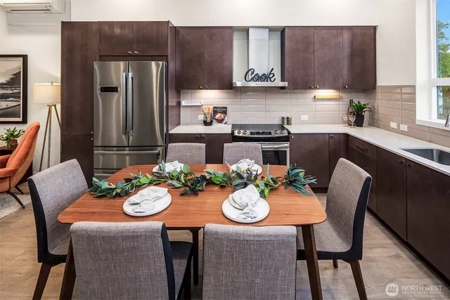 a kitchen with a table chairs refrigerator and microwave