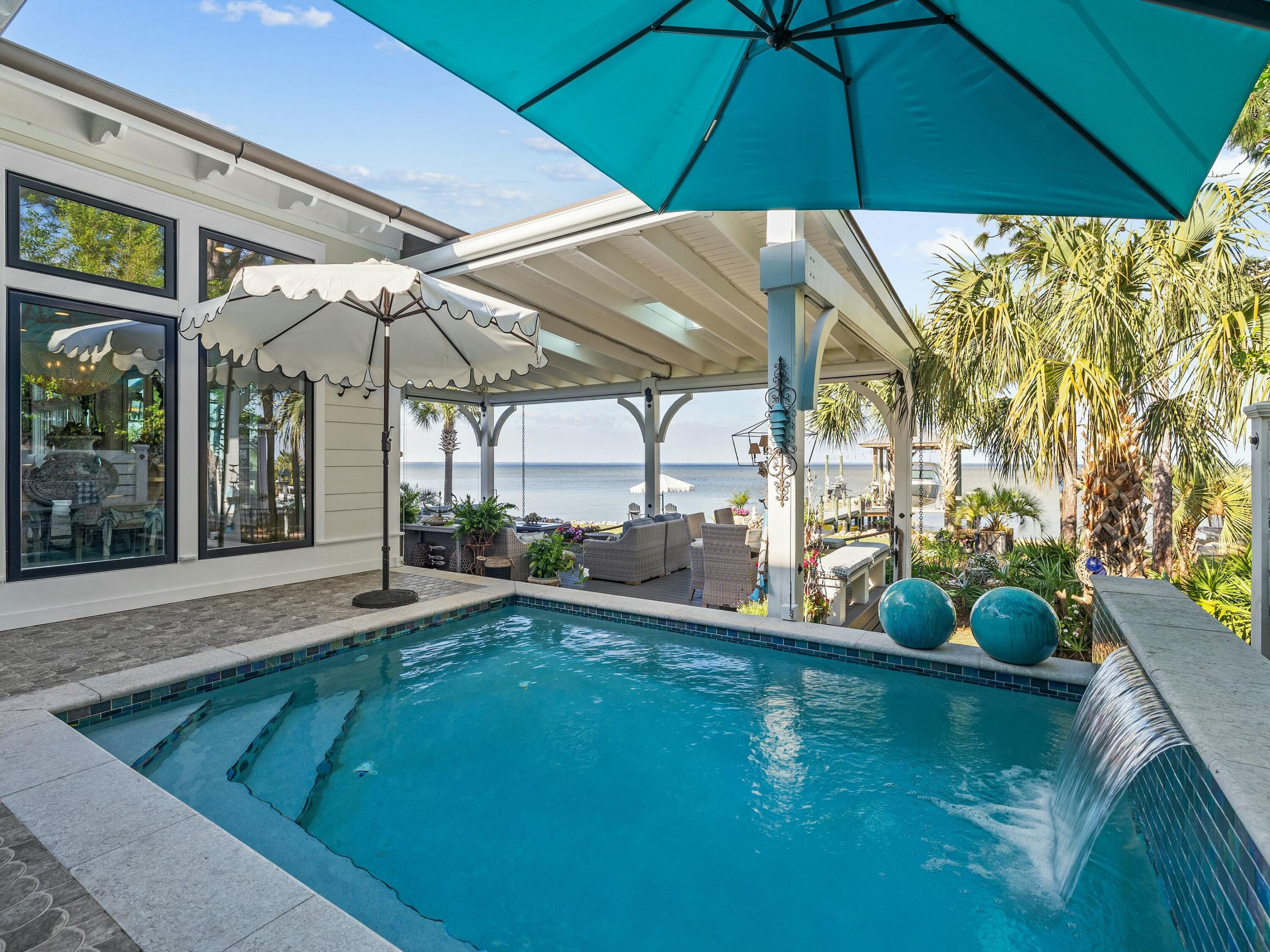 1521 Driftwood Point Road Santa Rosa Beach, FL 32459 - Photo 23 of 55 a view of a backyard with a table and chairs under an umbrella