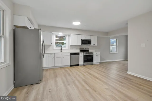 a kitchen with stainless steel appliances a refrigerator sink and cabinets