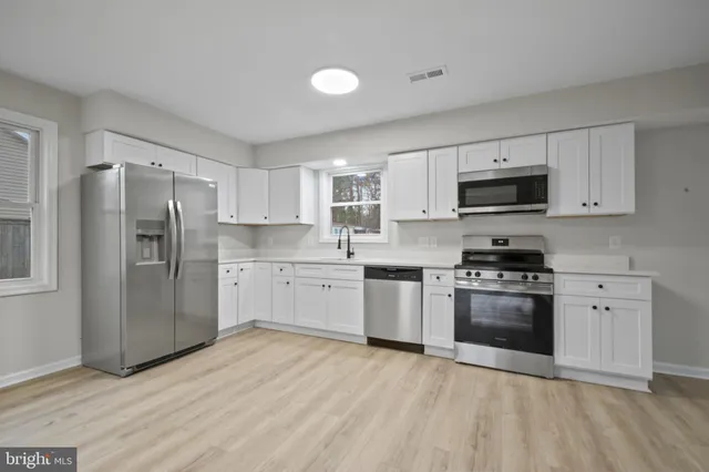 a kitchen with stainless steel appliances a refrigerator sink and stove